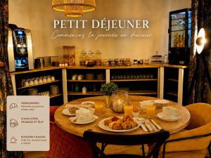 a table with plates of food on it in a restaurant at Le Mont Brouilly in Quincié-en-Beaujolais