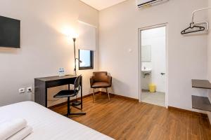 a bedroom with a bed and a desk and a mirror at Sans Stay Bintaro in Pondoklang