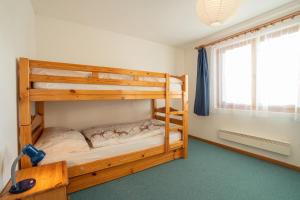 a bedroom with two bunk beds and a window at Chalet Capricorn in Bettmeralp