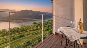 a balcony with a table and a view of a river at Gapyeong Rowa River view Pension in Gapyeong +10 photos