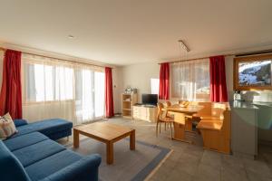 a living room with a blue couch and a table at Chalet Capricorn in Bettmeralp