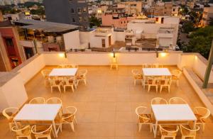 a rooftop patio with tables and chairs and a city at Hotel venus inn sajjangarh in Udaipur