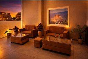 a lobby with couches and tables and a painting at Hotel venus inn sajjangarh in Udaipur