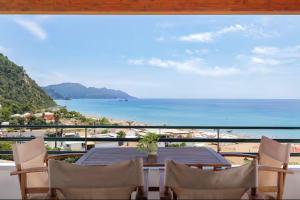a table and chairs on a balcony with a view of the beach at Coastal Bliss Apartments in Glyfada