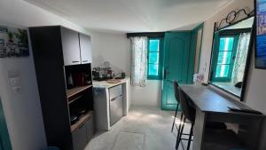 a kitchen with green cabinets and a desk in it at Kamares in Tholária