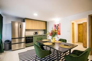 a kitchen with a table and chairs and a refrigerator at Apartments Flowers - Heated Pool Near Beach in Krk