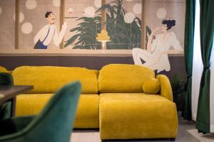 a yellow couch in a living room with a painting at Apartments Flowers - Heated Pool Near Beach in Krk +134 photos