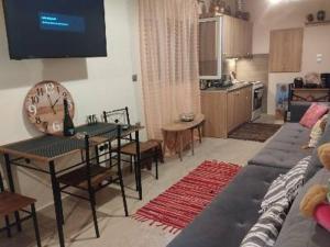 a living room with a couch and a tv on the wall at Anemomylos House in Kámpos +11 photos