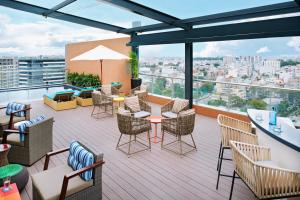 a rooftop patio with chairs and tables on a building at Ibis Saigon Airport in Ho Chi Minh City
