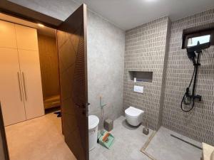 a bathroom with a toilet and a tv on the wall at Black sea batumi in Chakvi +15 photos