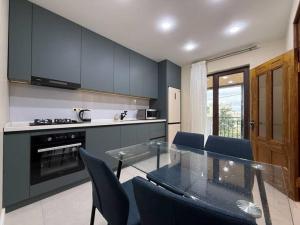 a kitchen with a glass table and blue cabinets at Black sea batumi in Chakvi