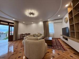 a living room with a couch and chairs and a television at Black sea batumi in Chakvi