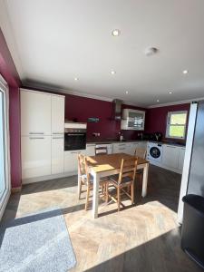 a kitchen with a table and chairs in a room at Crofters Cottage Barra 