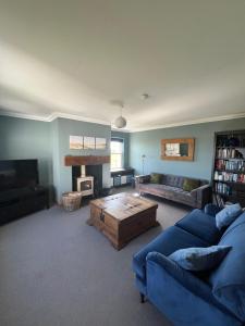 a living room with a blue couch and a coffee table at Crofters Cottage Barra 