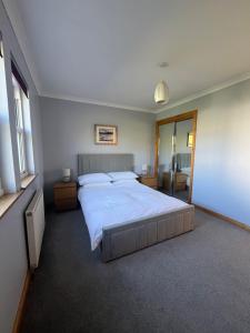 a bedroom with a large bed and a television at Crofters Cottage Barra 