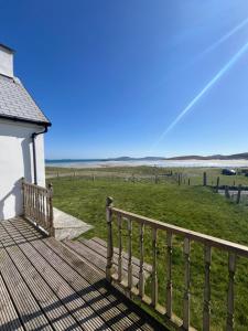 a wooden deck with a view of the ocean at Crofters Cottage Barra 