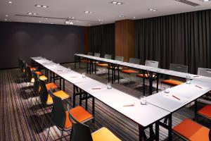 a conference room with long tables and chairs at Ibis Saigon Airport in Ho Chi Minh City
