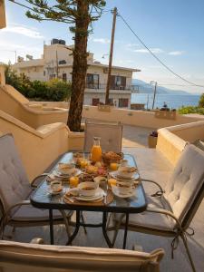 a table with food and orange juice on a patio at Soula Apartments & Studios in Palaiochora