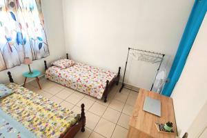 a small bedroom with two beds and a table at Ti' Palmiers in Pointe-Noire