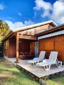 a house with two lounge chairs and a porch at Ti' Palmiers in Pointe-Noire