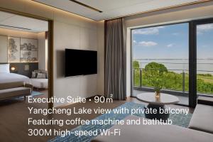 a room with a bed and a large window at Suzhou Marriott Hotel Yangcheng Lake in Suzhou
