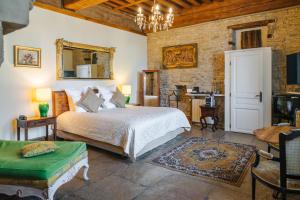 a bedroom with a bed and a table and a mirror at Hôtel Les Deux Chèvres Gevrey-Chambertin in Gevrey-Chambertin