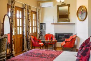 a bedroom with red chairs and a table and a fireplace at Hôtel Les Deux Chèvres Gevrey-Chambertin in Gevrey-Chambertin