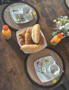 a table with two plates of breakfast food on it at Au bât Tournai chambre zen in Tournai