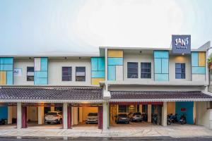 a building with cars parked in front of it at Sans Hotel Beskalan Malioboro in Yogyakarta