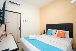 a bedroom with two beds with colorful pillows at Sans Hotel Beskalan Malioboro in Yogyakarta