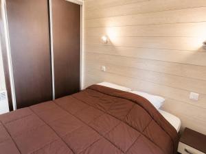 a bedroom with a bed in a wooden wall at Chalet privilège Parc de la Chesnaie in Autruy-sur-Juine