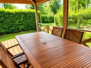 a wooden table and two chairs on a porch at Chalet privilège Parc de la Chesnaie in Autruy-sur-Juine