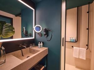 a bathroom with a sink and a mirror at Novotel Dhahran Hotel & Residences in Dhahran