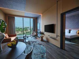 a hotel room with a bed and a television at Novotel Dhahran Hotel & Residences in Dhahran