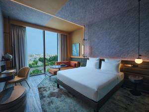 a hotel room with a bed and a large window at Novotel Dhahran Hotel & Residences in Dhahran