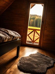 a bedroom with a bed and a window and a rug at Chata Nikki in Vrbno pod Pradědem +3 photos
