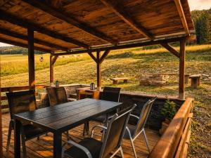 a wooden table and chairs under a wooden pergola at Chata Nikki in Vrbno pod Pradědem