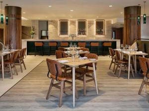 a restaurant with tables and chairs and a bar at Pullman Rotorua in Rotorua