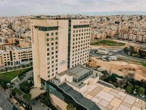 an aerial view of a building in a city at Mövenpick Hotel Amman in Amman