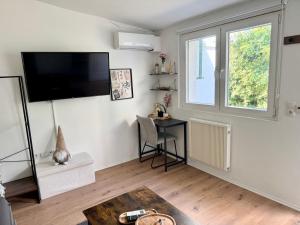 a living room with a flat screen tv on the wall at Mini Apartment mit Garten und Küche in Ilbenstadt