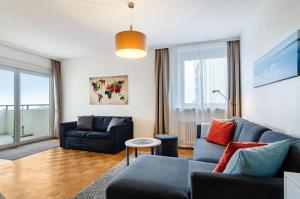 a living room with a blue couch and chairs at Ferienwohnung Alex in Meersburg