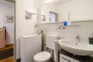 a bathroom with a white toilet and a sink at Ferienwohnung Alex in Meersburg +24 photos