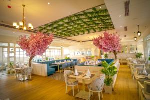a restaurant with tables and chairs and pink flowers at Hotel Krinoscco in Ayodhya