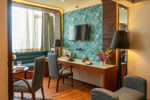 a hotel room with a desk and chairs at Regenta Orkos Kolkata by Royal Orchid Hotels Limited in Kolkata