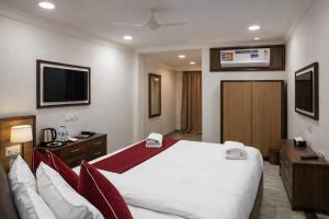 a hotel room with a large bed and a television at IndiGo Line Hotel - Banjara Hills X Beside Paradise Biryani in Hyderabad