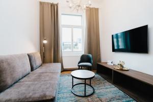 a living room with a couch and a tv at Rilke Apartments in Linz