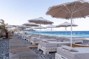 a row of chairs and umbrellas on a beach at Island Sea Side Hotel - Adults Only in Rhodes Town