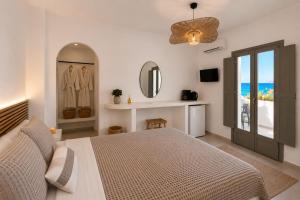 a bedroom with a bed and a mirror at Danа̃e Sun&Sea Stays in Livadi +6 photos