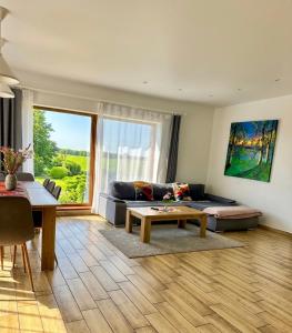 a living room with a couch and a table at Domo Vila in Druskininkai