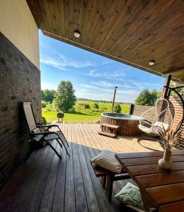 a patio with a table and chairs on a wooden deck at Domo Vila in Druskininkai
